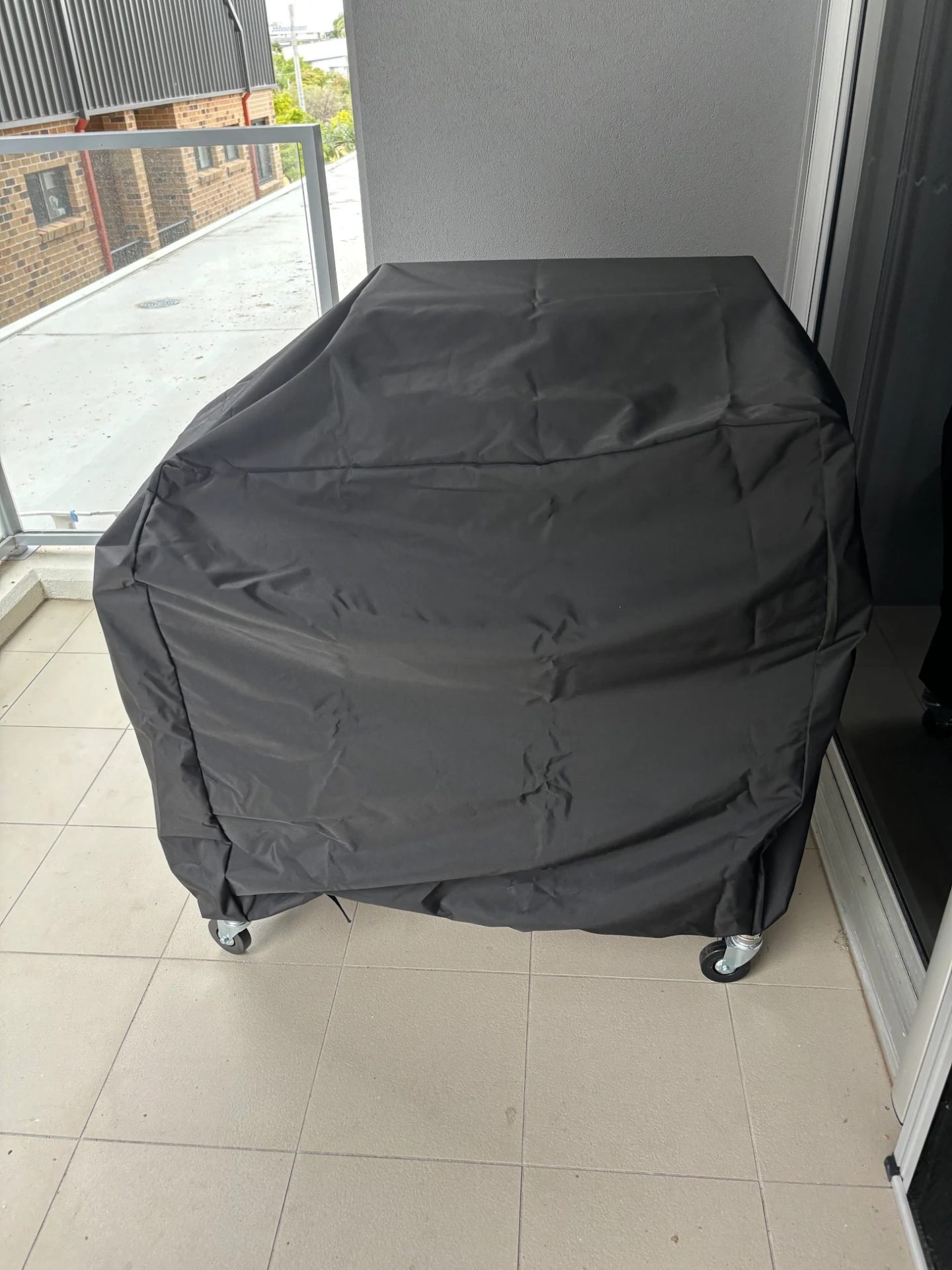 Custom made flat top grill cover in black fitted over a flat top grill on an apartment balcony – The Cover Company Canada